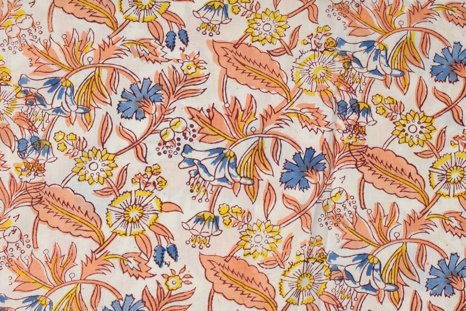 Close-up detail of Cornflower Daisy Trail block printed cotton fabric showing blue flowers and yellow daisies