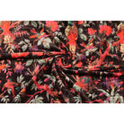 Rolled cotton velvet showing plush texture and radiating folds – black base with colorful bird design
