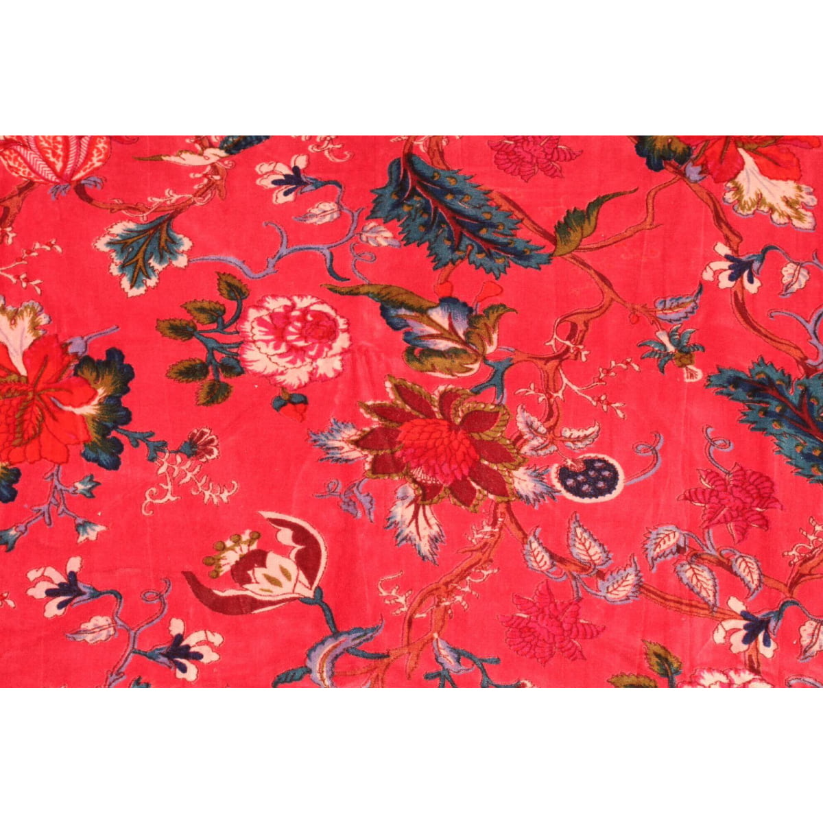 Close-up of hand-printed orange and blue floral pattern on red velvet