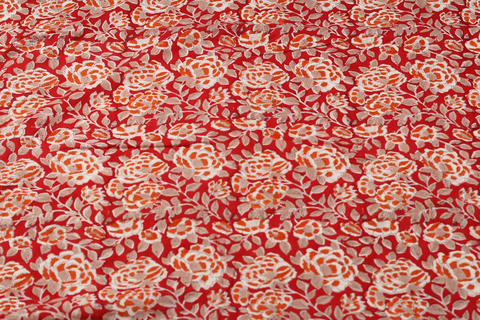 Crimson Rosewood hand block printed cotton fabric featuring ivory and burnt orange rose motifs on a crimson red background