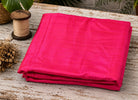 Electric Fuchsia dupion silk fabric folded on a tabletop showing vibrant pink raw silk with luminous sheen