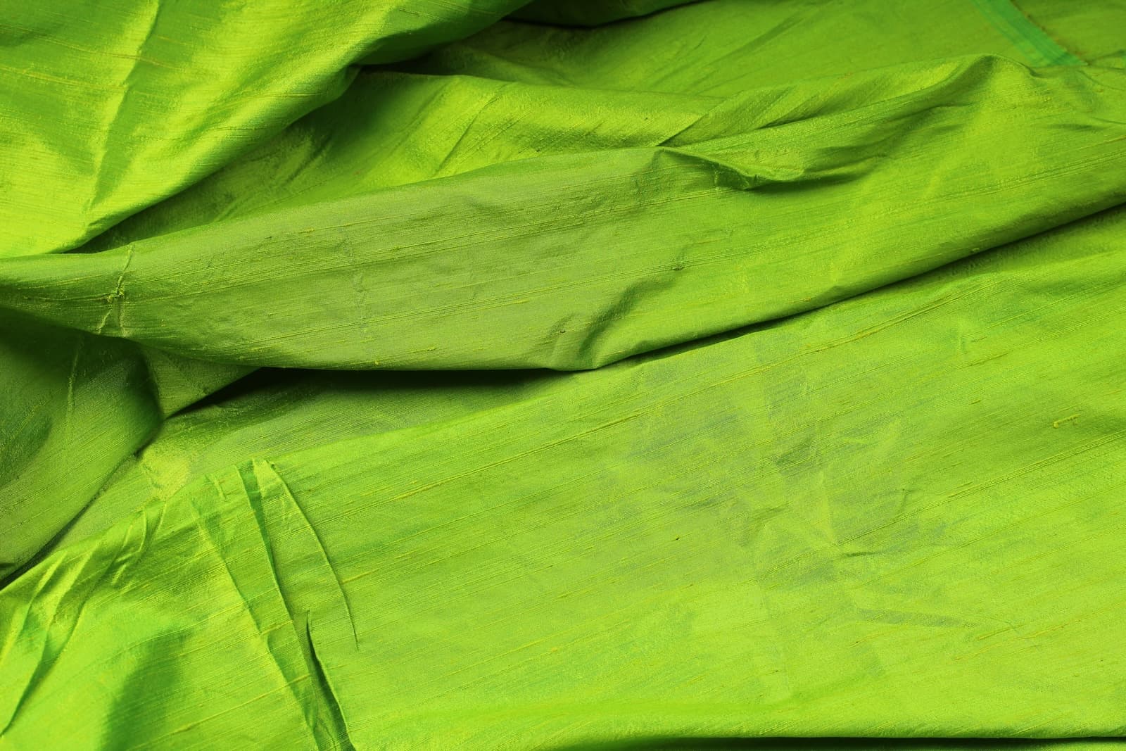 Lime Green Dupion Silk Fabric displayed with soft folds revealing natural silk texture, luminous finish, and vivid lime-green tones