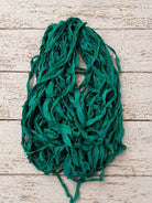 Close-up of emerald chiffon silk ribbon yarn highlighting soft chiffon weave and rich green color