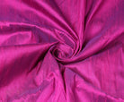 Fuchsia Magenta dupion silk fabric arranged in a swirl highlighting iridescent sheen, vibrant pink colour, and natural raw silk texture