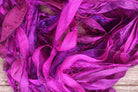 Close-up texture of Wild Orchid sari silk ribbon featuring vivid fuchsia and magenta silk strips.