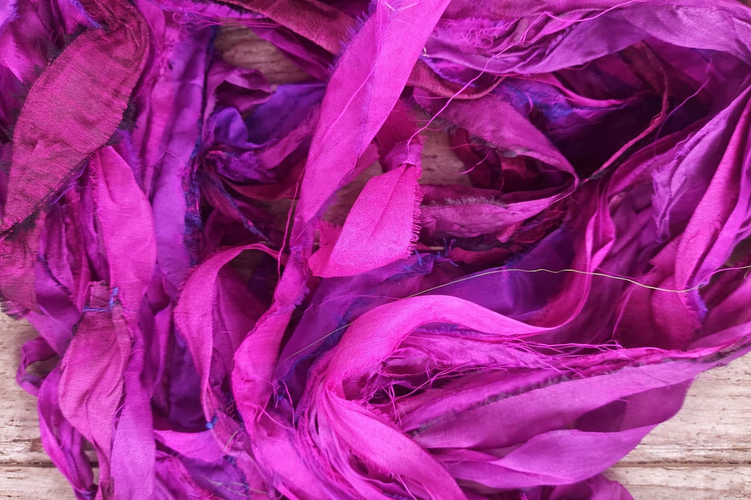 Close-up texture of Wild Orchid sari silk ribbon featuring vivid fuchsia and magenta silk strips.