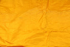 Close-up of Golden Marigold Dupion Silk Fabric showing natural slub texture, woven silk detail, and subtle colour variation