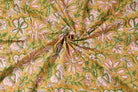 Hand block printed golden cotton fabric draped to showcase pink floral pattern and soft cotton texture