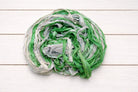 Coiled spring green sari silk ribbon yarn showing soft texture and color variation