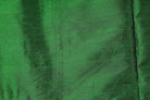 Emerald Green Dupion Silk Fabric displayed in flowing folds revealing its crisp texture, silk lustre, and deep emerald colouring
