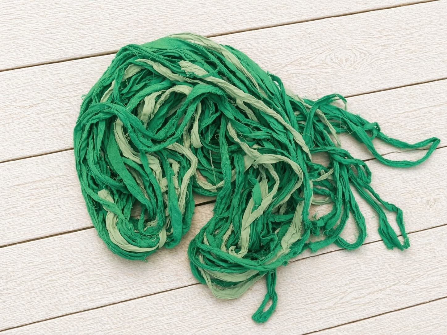 Recycled sari silk ribbon yarn bundle showing fern green and sage silk strands