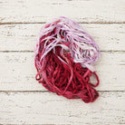 Berry Blossom sari silk ribbon yarn coiled in crimson rose and lavender shades