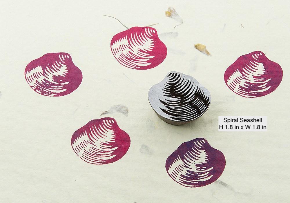 Spiral seashell hand carved wooden stamp creating bold textile print patterns