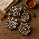 Set of hand carved Indian wooden printing blocks featuring mandala and paisley designs on rustic wooden background with textile printing tools.