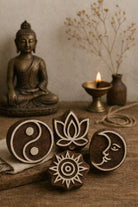 Hand carved wooden printing block set with moon, lotus, sunburst and yin yang spiritual symbols displayed on rustic table