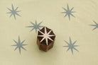 Hand carved 8 point star wooden block stamp printing grey starburst pattern on paper