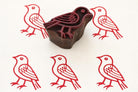 Hand carved wooden bird printing block with red stamped pattern on fabric