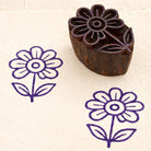 Hand carved flower wooden printing block with purple floral stamp on fabric