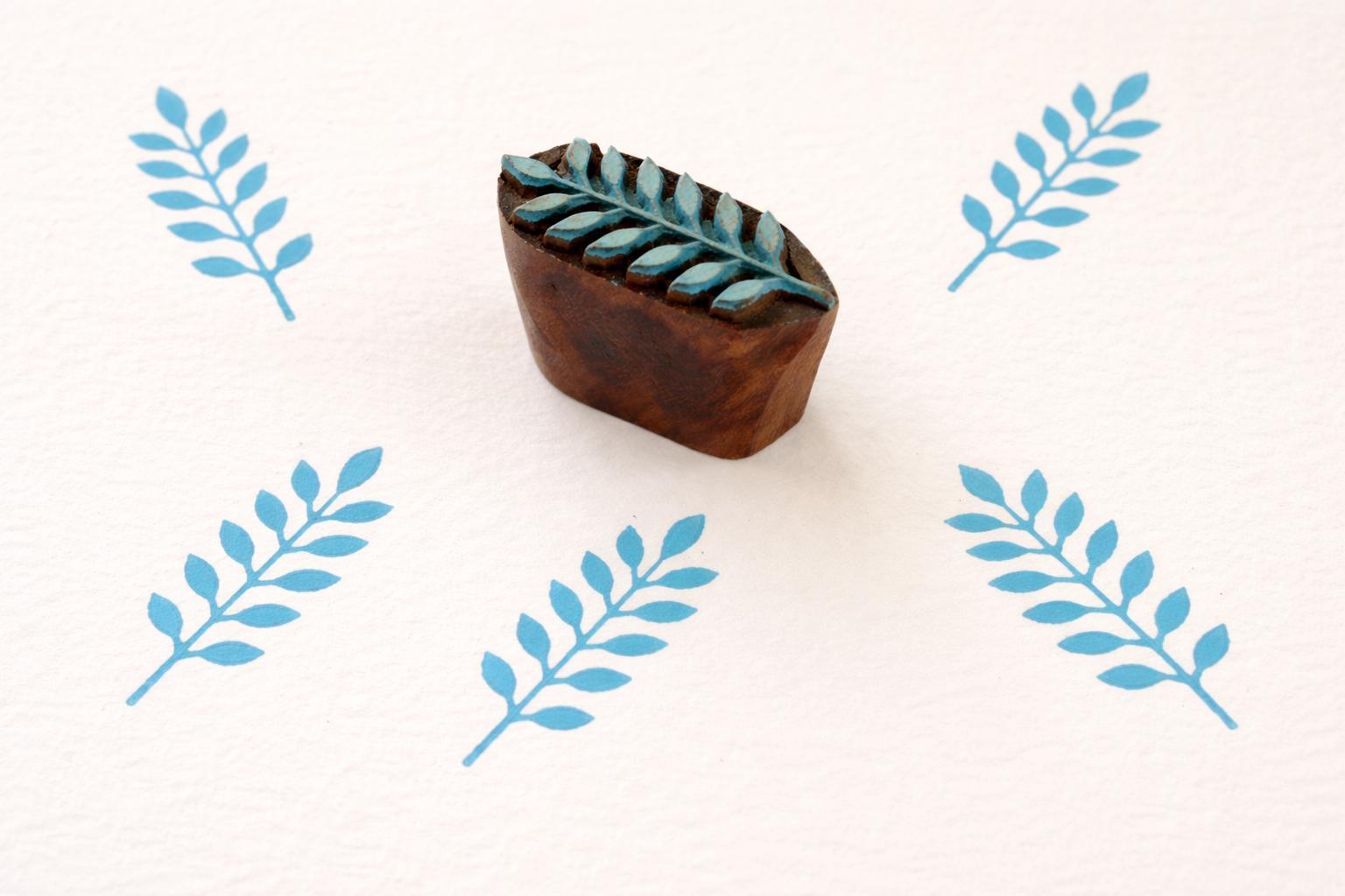 Indian wooden leaf block printing stamp creating blue botanical pattern on fabric