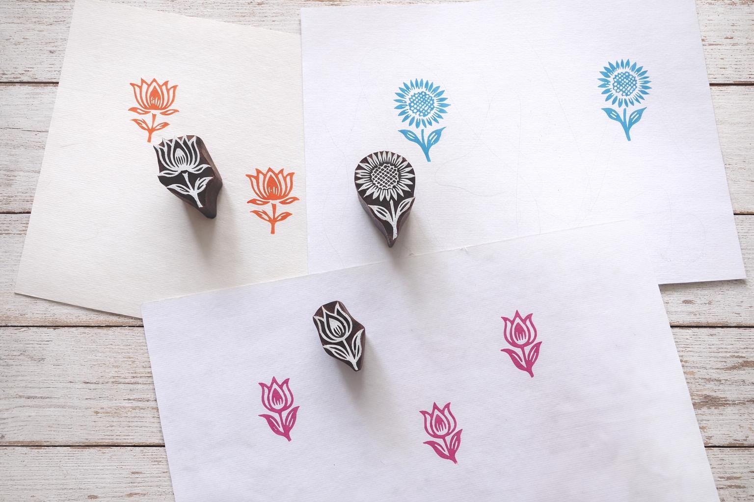 Hand carved wooden floral block printing stamps showing lotus tulip and sunflower prints on handmade paper.