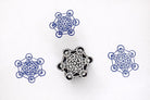 Hand carved wooden Metatron’s Cube block printing stamp creating blue sacred geometry prints on white paper.