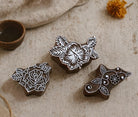 Set of three hand carved wooden floral block printing stamps featuring rose, hibiscus and vine design on neutral fabric background.