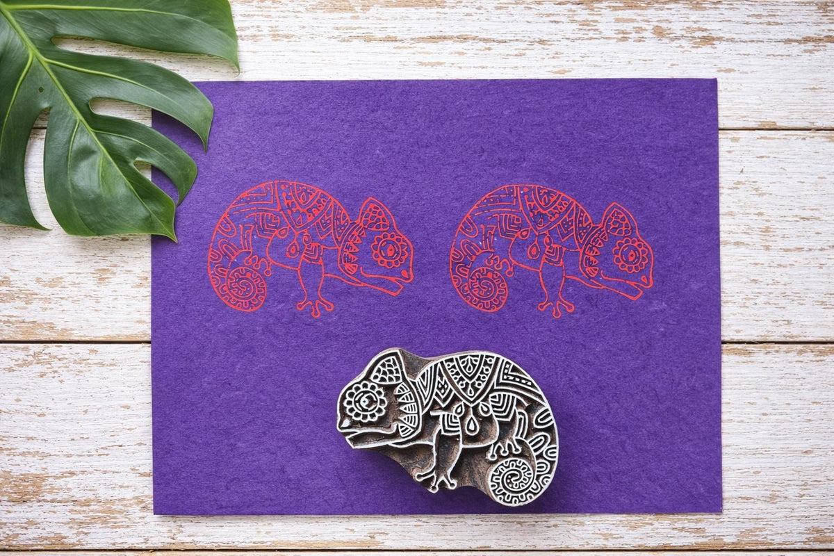 Hand carved wooden chameleon block printing stamp with detailed patterns on rustic wooden background.