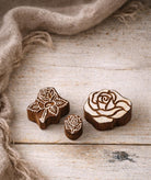 Set of hand carved Indian wooden rose printing stamps in different sizes on off white background.