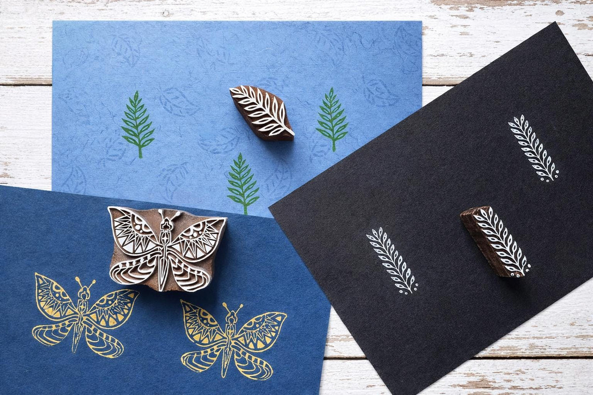 Indian wooden printing blocks used for textile printing with butterfly and leaf fabric stamp patterns.