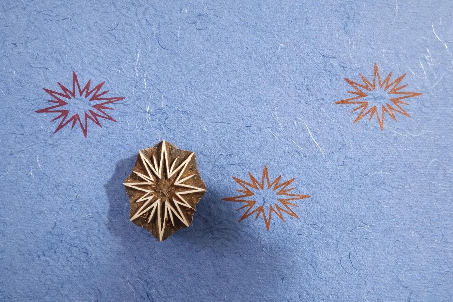 Hand carved starburst wooden printing block used as textile stamp for fabric printing, clay and pottery decoration.