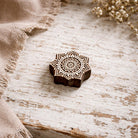 Hand carved wooden mandala flower block printing stamp on a white table hero image for block printing on paper, fabric, clay