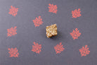 Wooden block printing stamp creating red leaf pattern prints on dark blue paper.