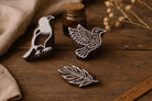 Hand carved wooden block printing stamp set featuring bird and leaf motifs displayed on rustic wooden table with natural linen cloth and dried flowers.