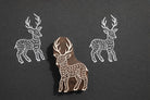 Hand carved wooden deer block printing stamp creating white deer prints on black paper.