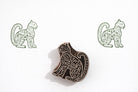Hand carved wooden spotted leopard block printing stamp creating green wildlife prints on white paper.