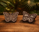 Hand carved wooden butterfly block printing stamps on wooden table, featuring floral garden butterfly and wild meadow butterfly designs, natural brown wood blocks with cream carved surface