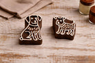 Set of two handmade wooden dog block printing stamps on rustic table