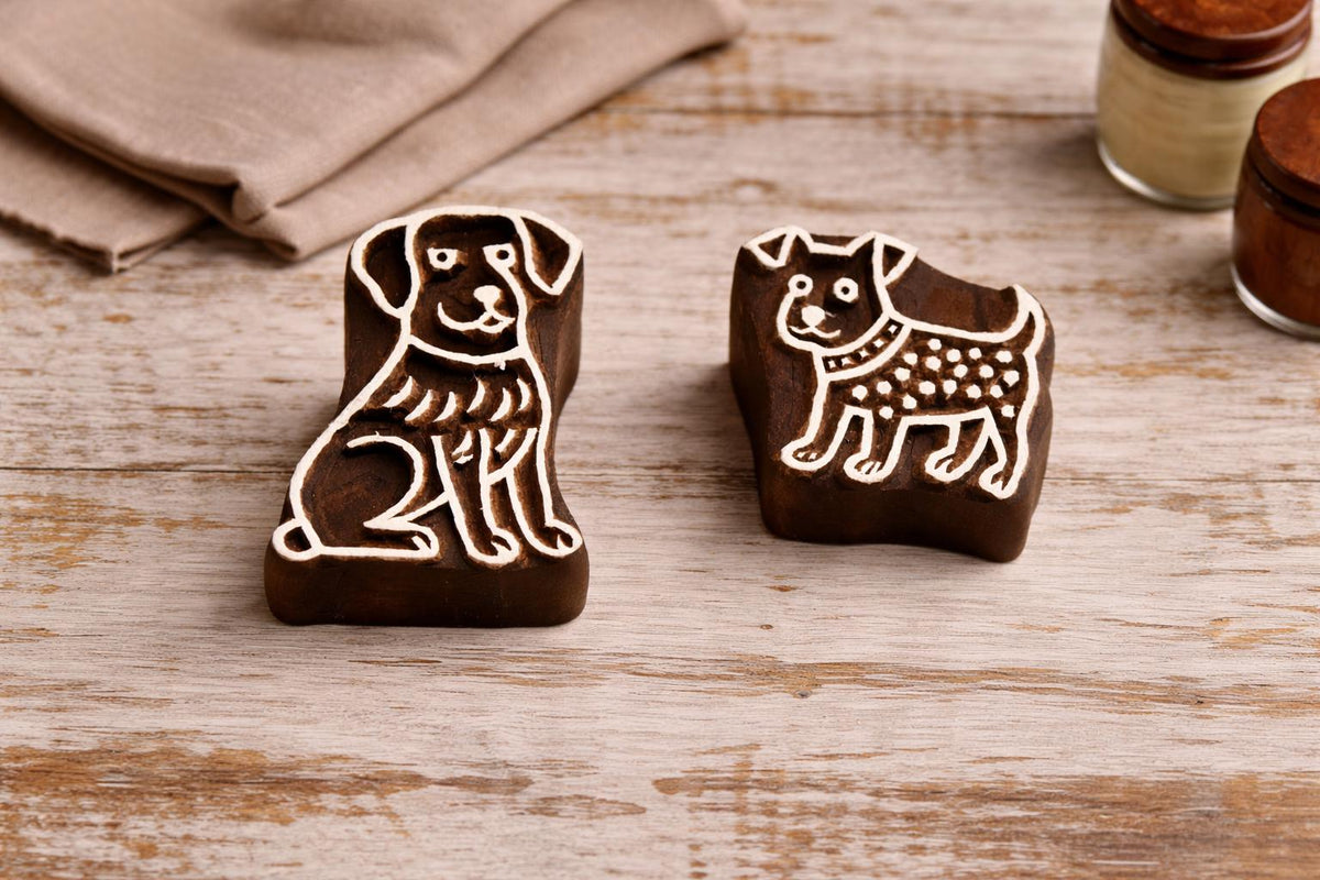Set of two handmade wooden dog block printing stamps on rustic table