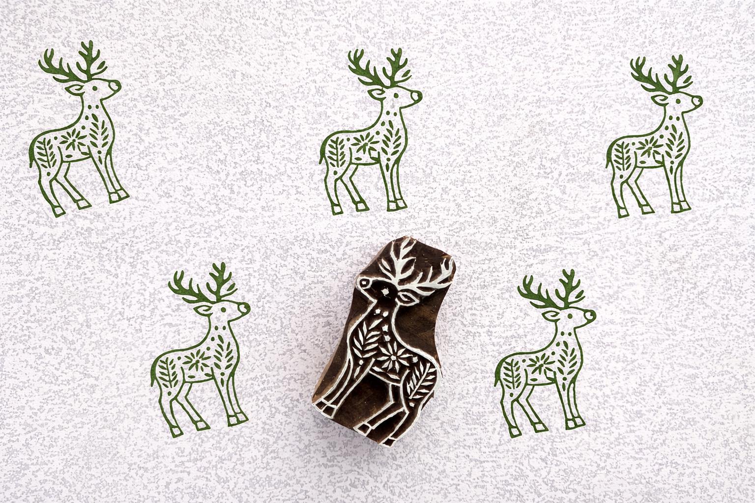 Deer block print pattern in green ink on handmade paper with stamp