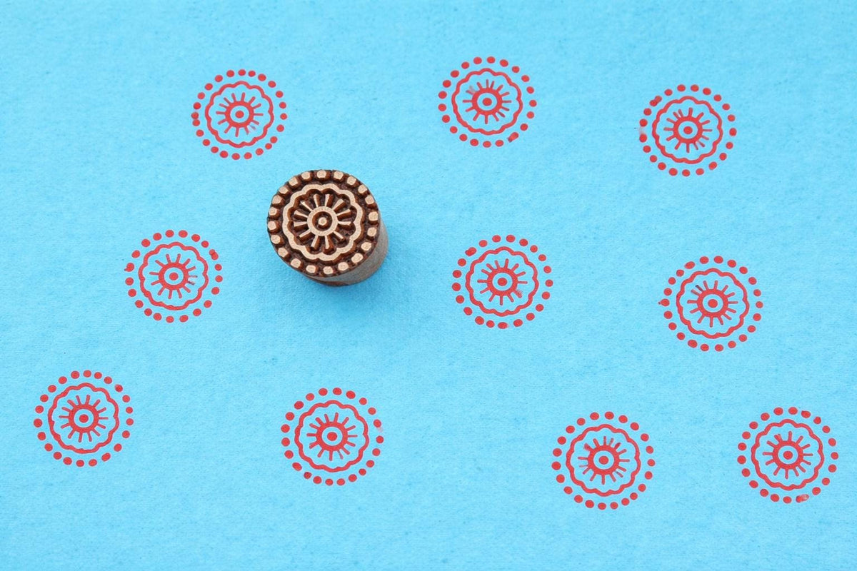Floral wooden block stamp with red circular pattern on blue background