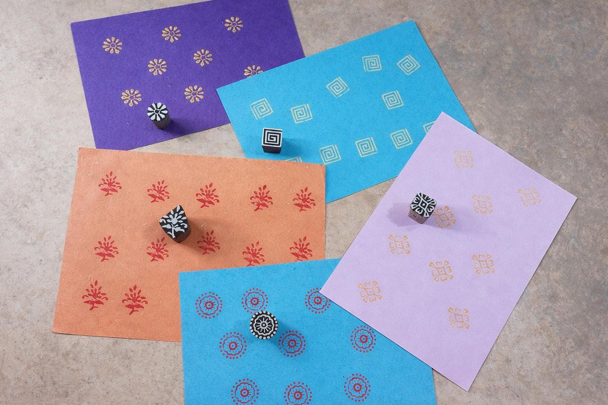 Collection of wooden block printing stamps with colorful printed samples