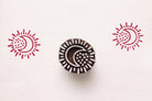 Hand carved wooden crescent moon block printing stamp creating red moon sun prints on white paper.