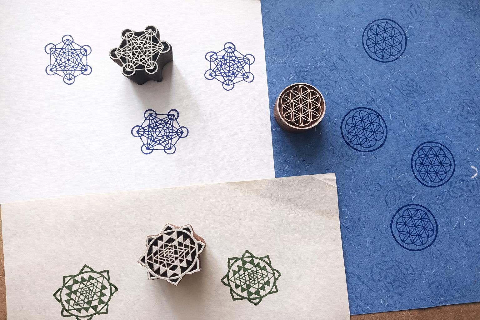 Hand carved sacred geometry block printing stamps showing Metatron cube, Sri Yantra and Flower of Life prints on handmade paper.