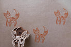Hand-carved wooden fox block stamp with orange fox prints on fabric, featuring a folk art style design
