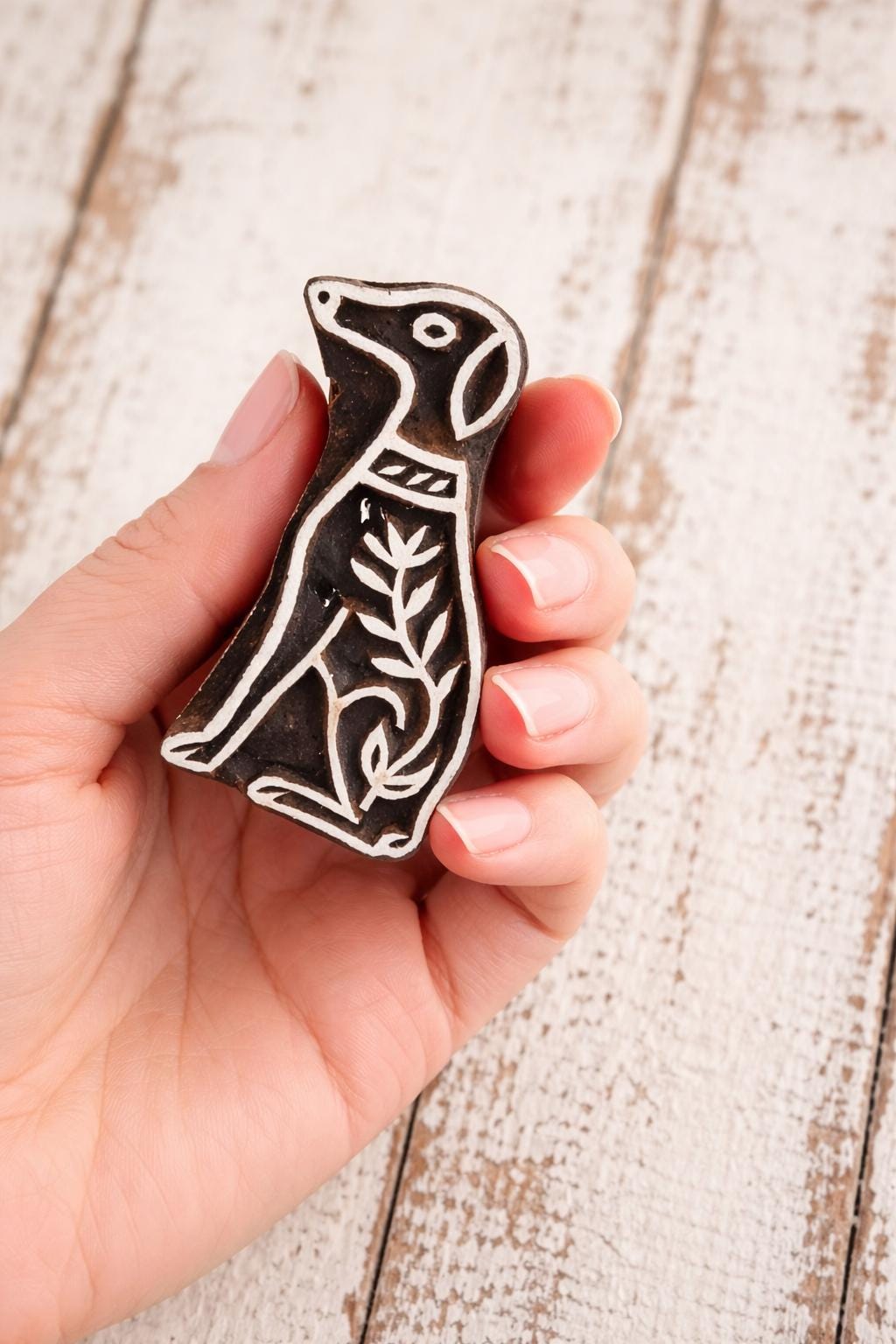 Hand-carved wooden Greyhound dog block stamp held to show size