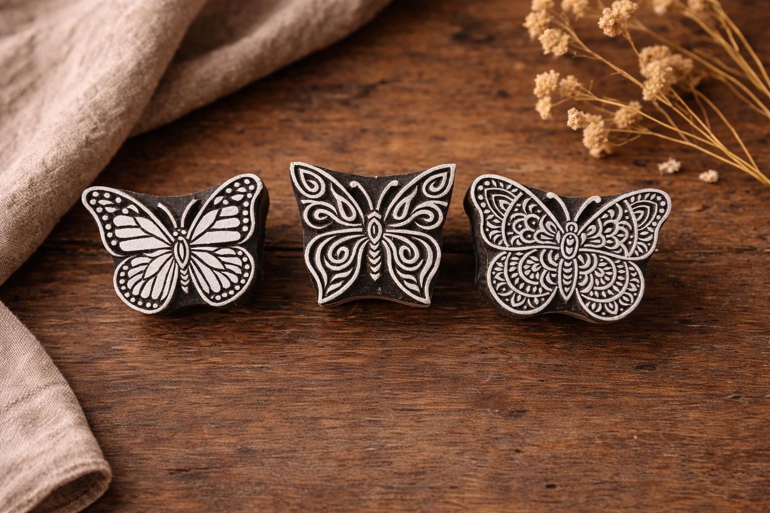 three hand carved wooden butterfly stamps on rustic wooden surface