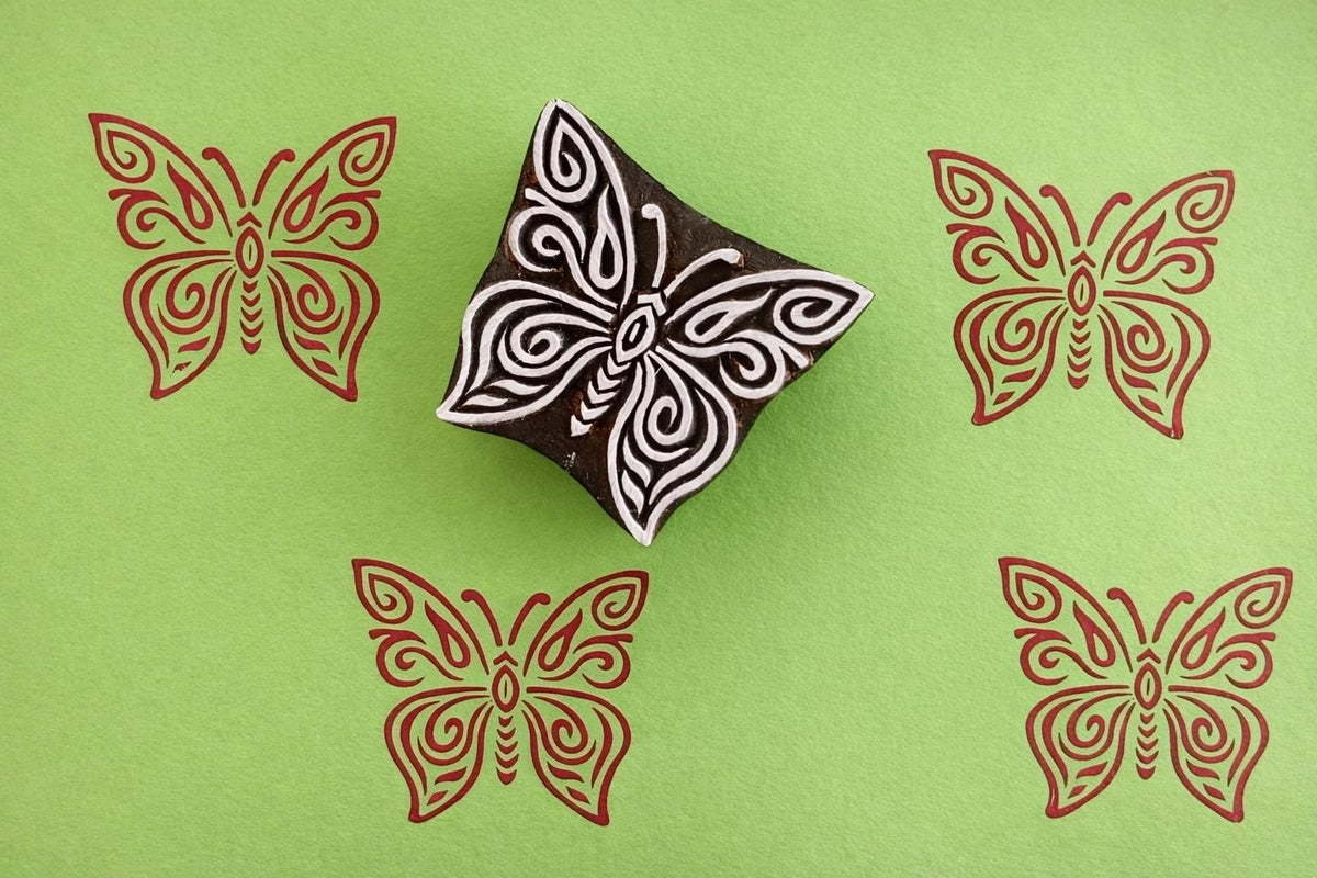 lacewing butterfly stamp with red ink prints on green background