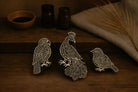 Set of three hand carved wooden block stamps featuring a parrot, peacock, and small bird on a rustic wooden surface