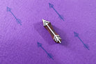 Single wooden arrow stamp creating a repeating minimalist arrow pattern on purple paper.