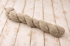 Natural undyed hemp wool blend yarn skein laid on rustic wooden background